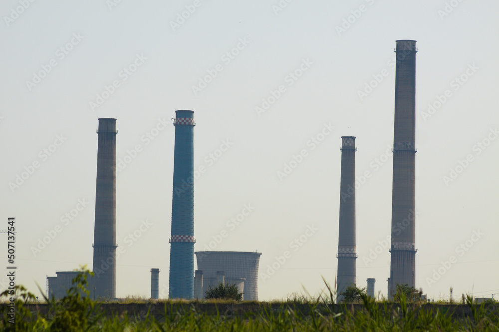 Closeup of furnaces with polluted sky on background