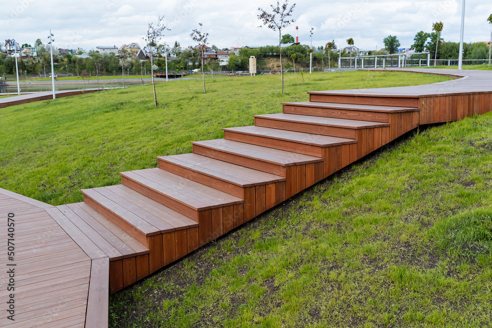 Wooden steps in the city park, a beautiful place to relax and walk in nature, a staircase of boards, the landscape of the park design of the territory.