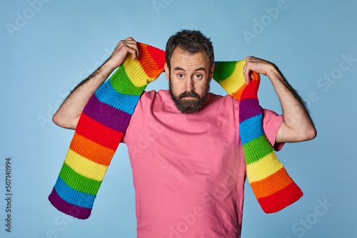 portrait gay man with rainbow colored scarf. Gay pride day. lgbq community. photo