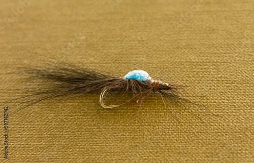 Tied flies, bait for outdoor activities, fly fishing. Do-it-yourself accessory for catching insects with your own hands. Colorful feathers and hooks are used to create fishing bait. photo