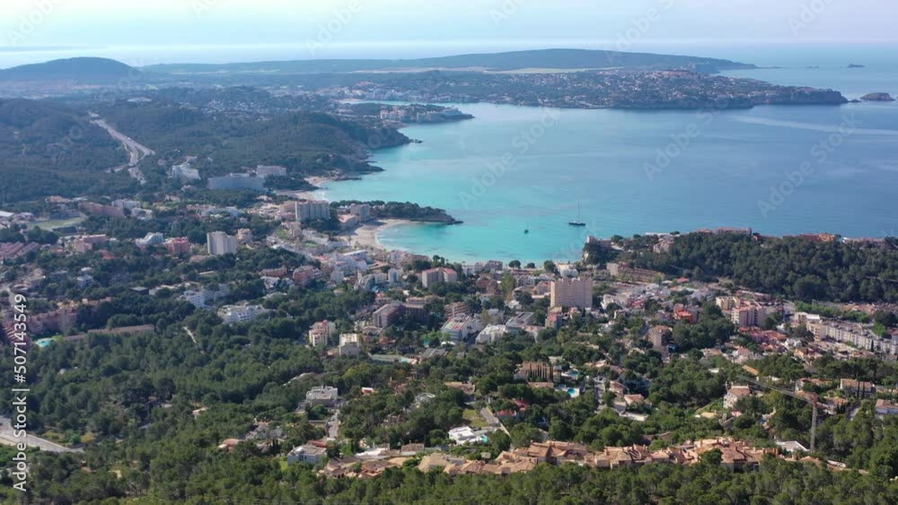 Aerial orbiting shot flying around Peguera from mountain side with hotels and beaches. Sea in background. Mallorca, Balearic Islands, Spain Aerial orbiting shot flying around Peguera from mountain side with hotels and beaches. Sea in background. Mallorca, Balearic Islands, Spain