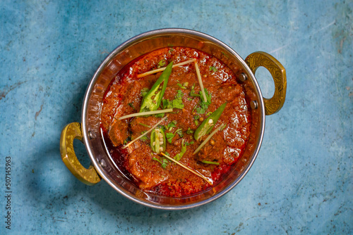Spicyy mutton karahi masala with napkin isolated on wooden table top view of indian, pakistani food