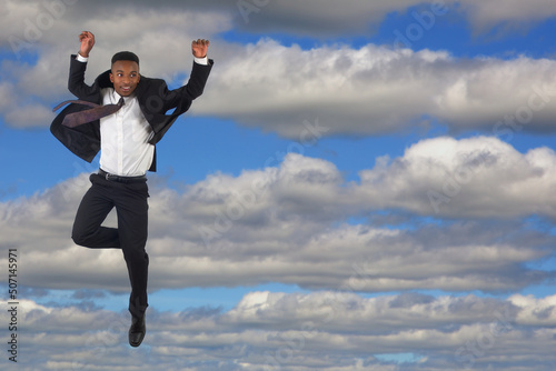 young businessman wearing suit and tie jumping into cloudy sky success and freedom life