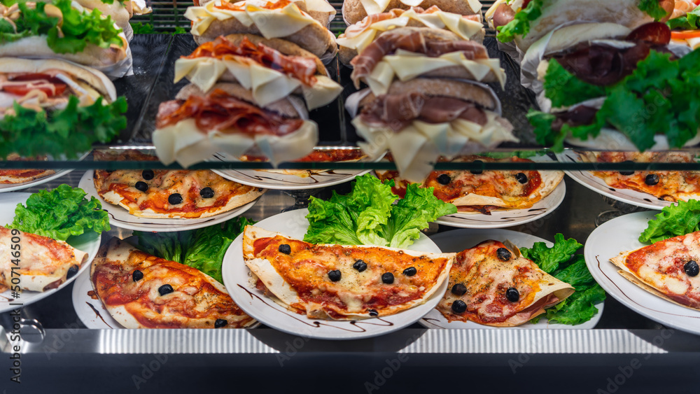 Glazed showcase inside a cafe with fresh Italian dishes and herbs in Milan, national Italian cuisine for fast food, close-up Glazed showcase inside a cafe with fresh Italian dishes and herbs in Milan, national Italian cuisine for fast food, close-up