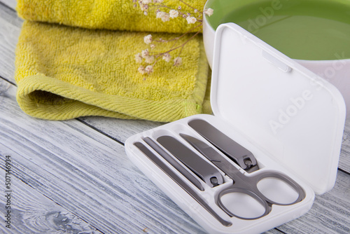 Manicure set on the background of light wood and green towel