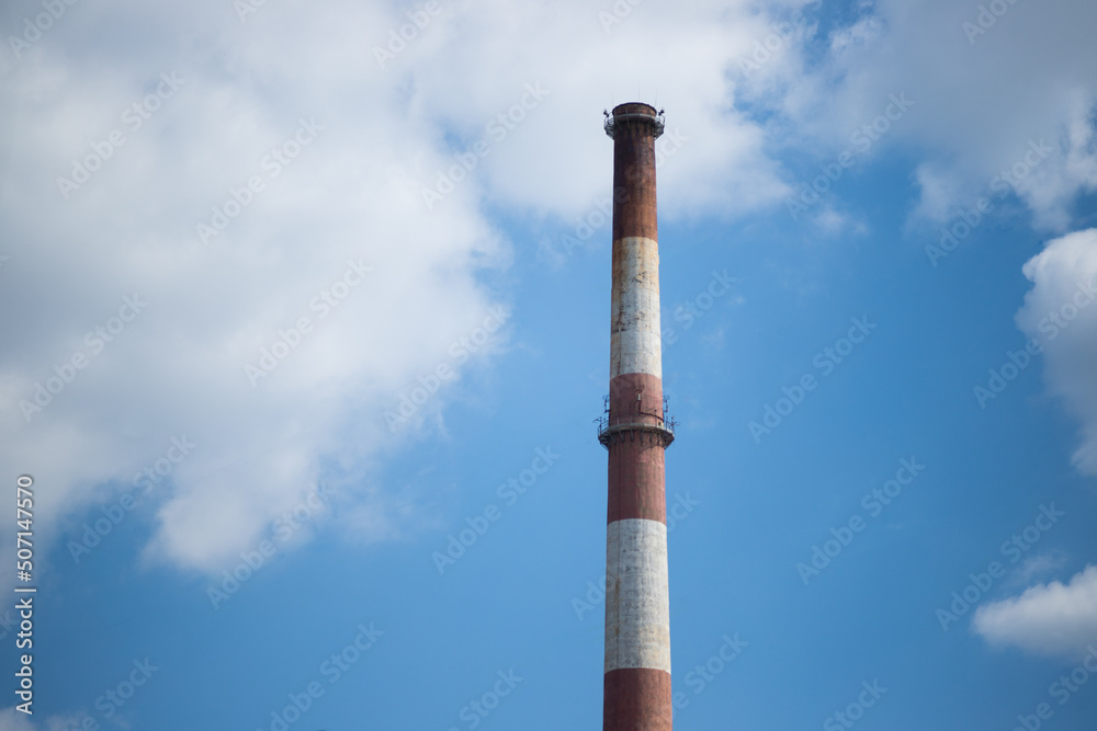 Heat and power plant chimney on the background blue sky Heat and power plant chimney on the background blue sky