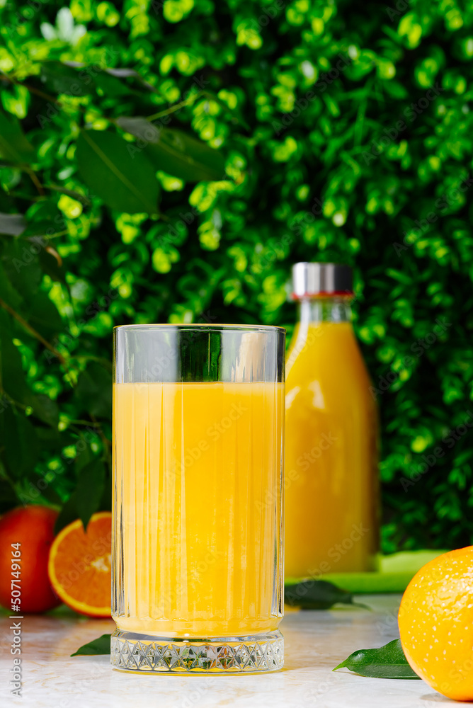 Glass of orange juice and orange juice bottles. Glass and bottle of organic tropical juice Glass of orange juice and orange juice bottles. Glass and bottle of organic tropical juice