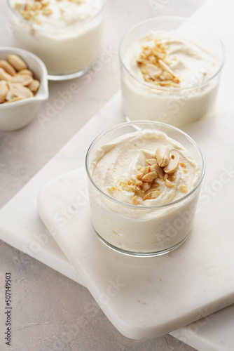 Creamy dairy yoghurt dessert with mascarpone, cream cheese and peanut butter in glasses on marble tray