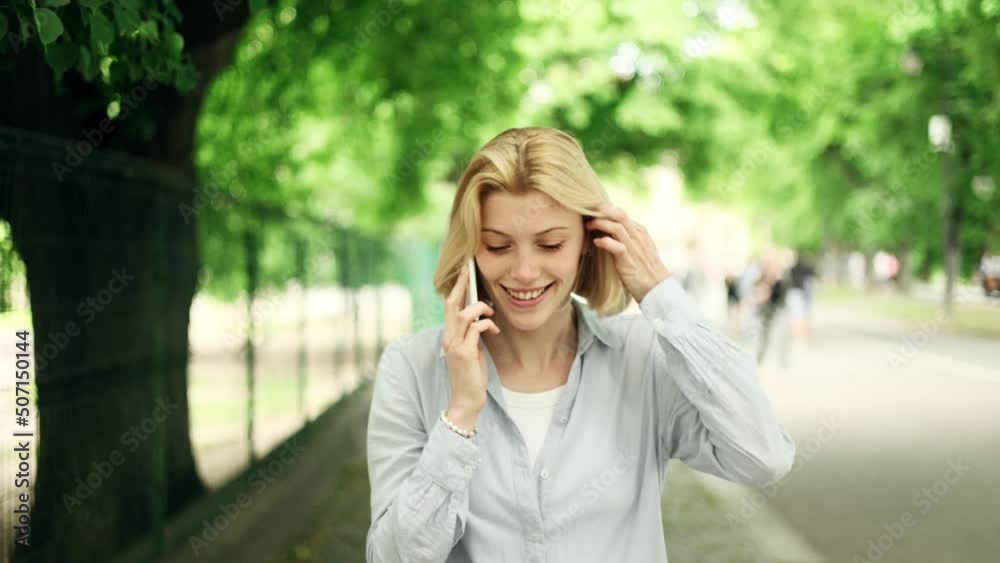 Portrait of attractive blond girl having phone talk. Young beautiful girl at the city street. Happy smiling girl walking forward. High quality 4k footage Portrait of attractive blond girl having phone talk. Young beautiful girl at the city street. Happy smiling girl walking forward. High quality 4k footage