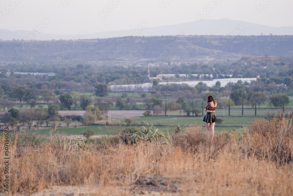Wide landscape with a pretty woman in a skirt