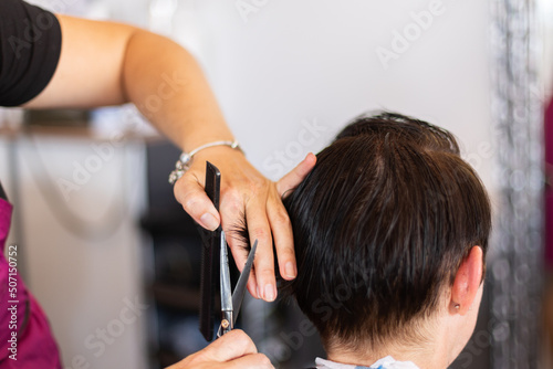 Cutting hair at hairdresser. Treat hair at beauty salon. Closeup.
