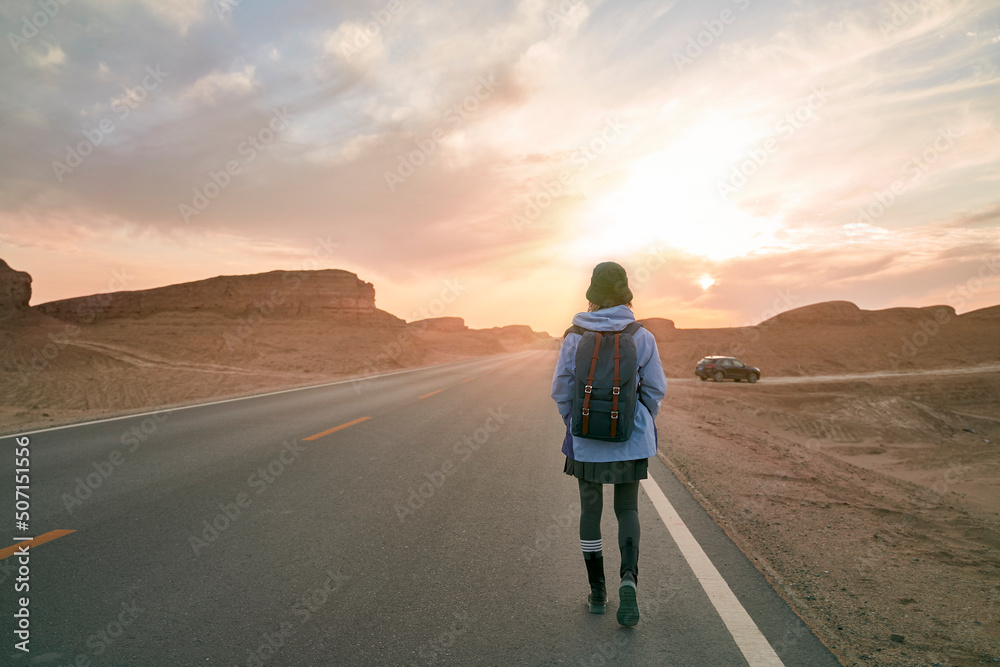 Αυτοκόλλητο young asian female traveler walking on desert highway