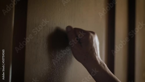  Woman persistently knocking on the door, close-up photo