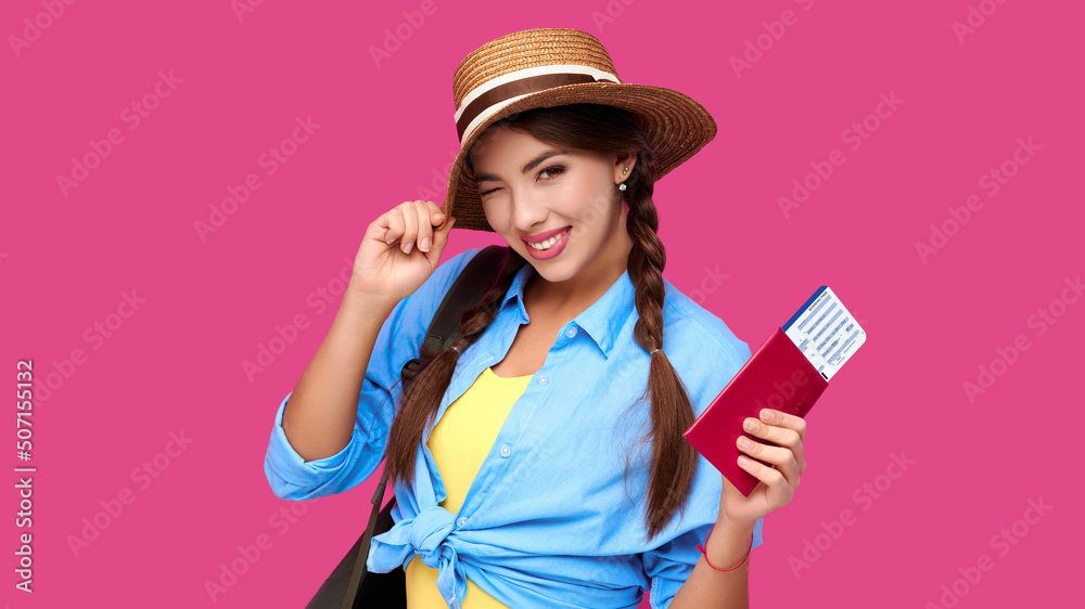 Smiling woman traveler in straw hat and backpack holding passport with plane ticket over pink isolate background Smiling woman traveler in straw hat and backpack holding passport with plane ticket over pink isolate background