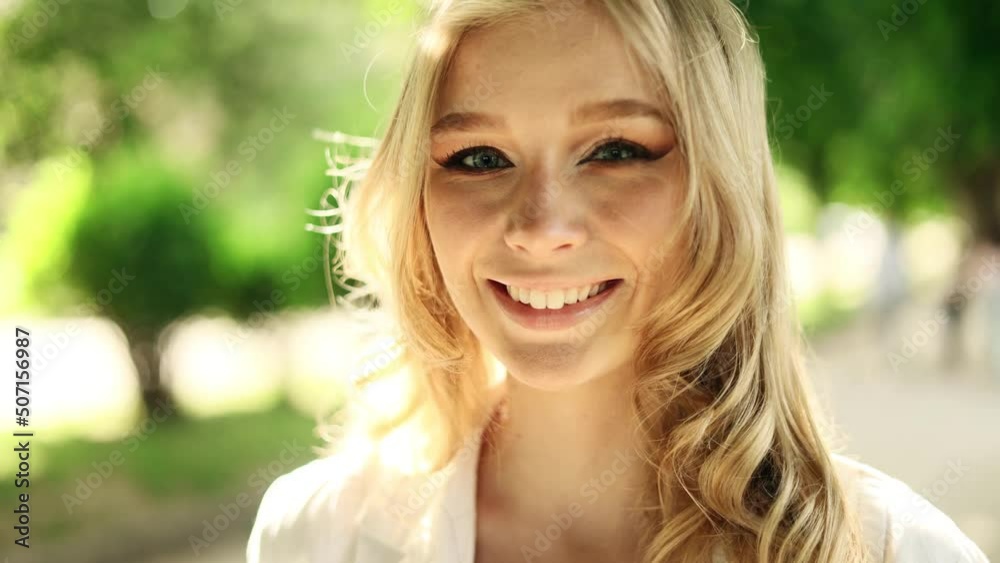 Portrait of attractive smiling woman while standing in the city street. Beautiful woman looking at the camera outside. Portrait of attractive smiling woman while standing in the city street. Beautiful woman looking at the camera outside.