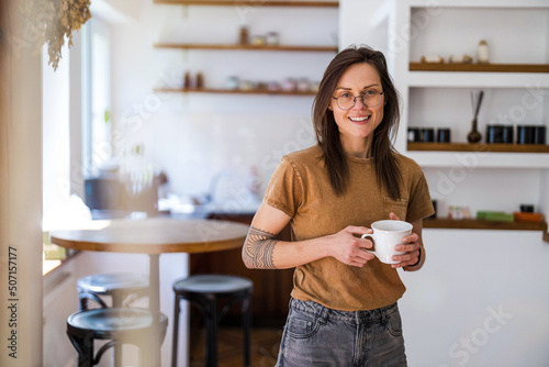 Portrait of a young woman standing in her home 