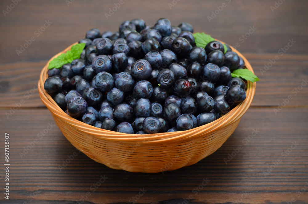 basket with forest blueberries on a wooden background basket with forest blueberries on a wooden background