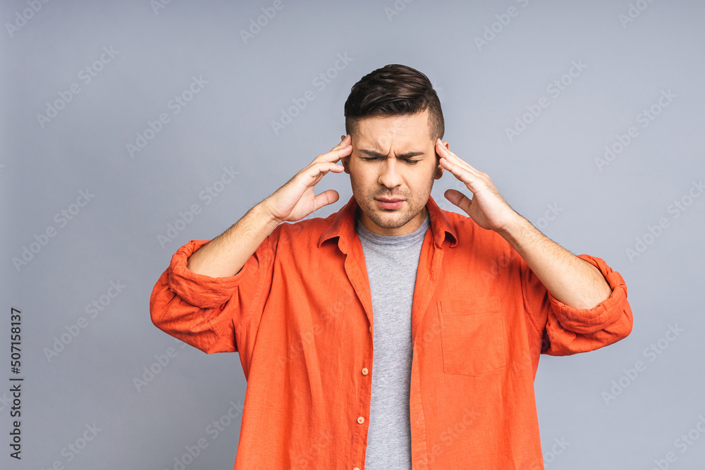 People, crisis, emotions and stress concept - unhappy tired ukrainian man suffering from head ache at home. Isolated over grey white background.