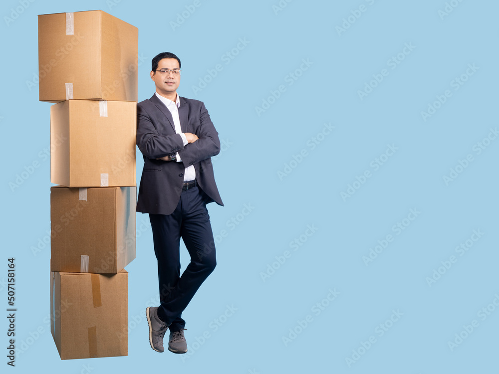 Successful man with boxes. Guy standing in full growth crossed his arms. Relocation metaphor boxes. Concept change of residence. Boxes with personal belongings for relocation. Man model on turquoise Successful man with boxes. Guy standing in full growth crossed his arms. Relocation metaphor boxes. Concept change of residence. Boxes with personal belongings for relocation. Man model on turquoise
