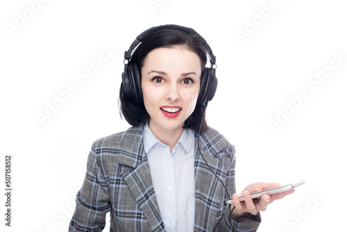 smiling woman in office suit listening to music in big full size headphones. High quality photo