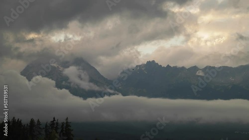 Timelapse of dramatic stormy clouds covering High Tatras rocky mountains during sunset in spring season, Slovakia. 