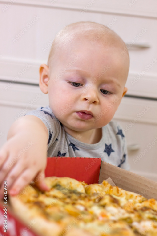 Cute little kid boy taking a slice of pizza. Cute little kid boy taking a slice of pizza.