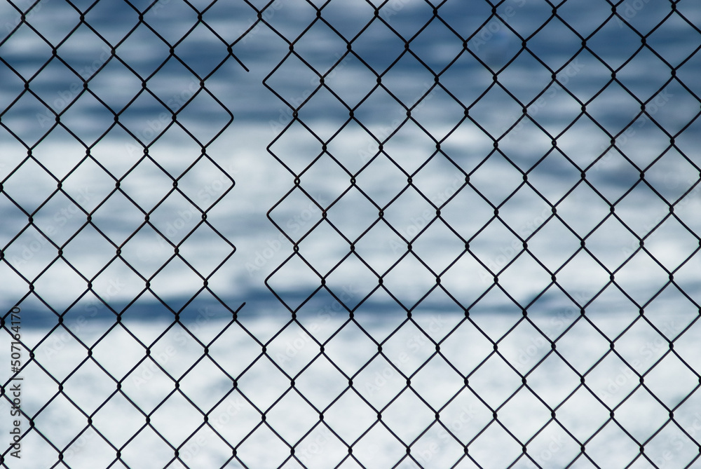gray background, in the photo a metal mesh on a background of white snow gray background, in the photo a metal mesh on a background of white snow