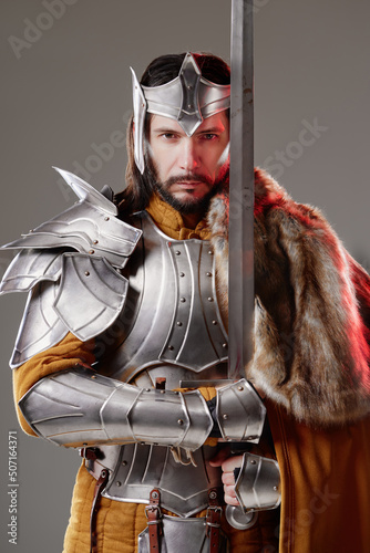 Fotografie, Obraz The King. Handsome Medieval knight in armor holding sword.