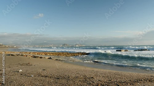 Wallpaper Mural Seaside landscape. Spanish sandy beach sea shore with splashing waves. Mediterranean coast with seaside Alacant city in the distance. Torontodigital.ca