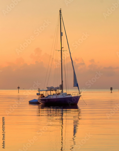 sailboat at sunrise on golden waters