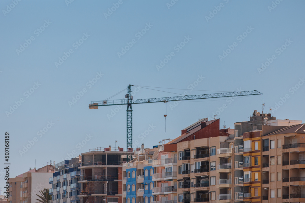 Construction crane on the background of houses
