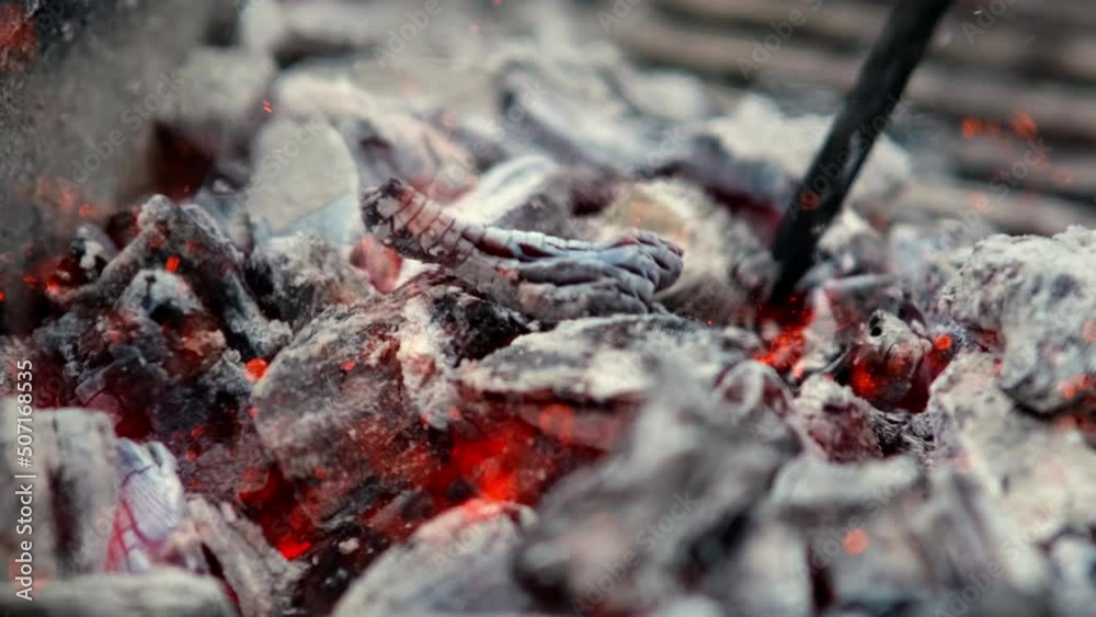 a close up of some very hot charcoal burning in a grill in slow motion and flames a close up of some very hot charcoal burning in a grill in slow motion and flames