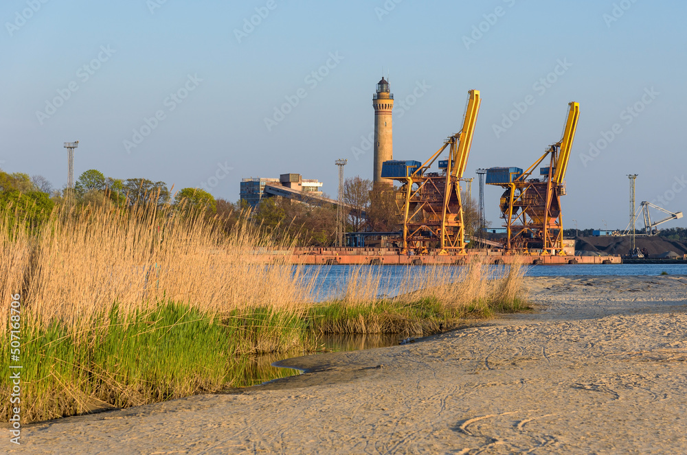 Port cranes and a lighthouse in Swinoujscie