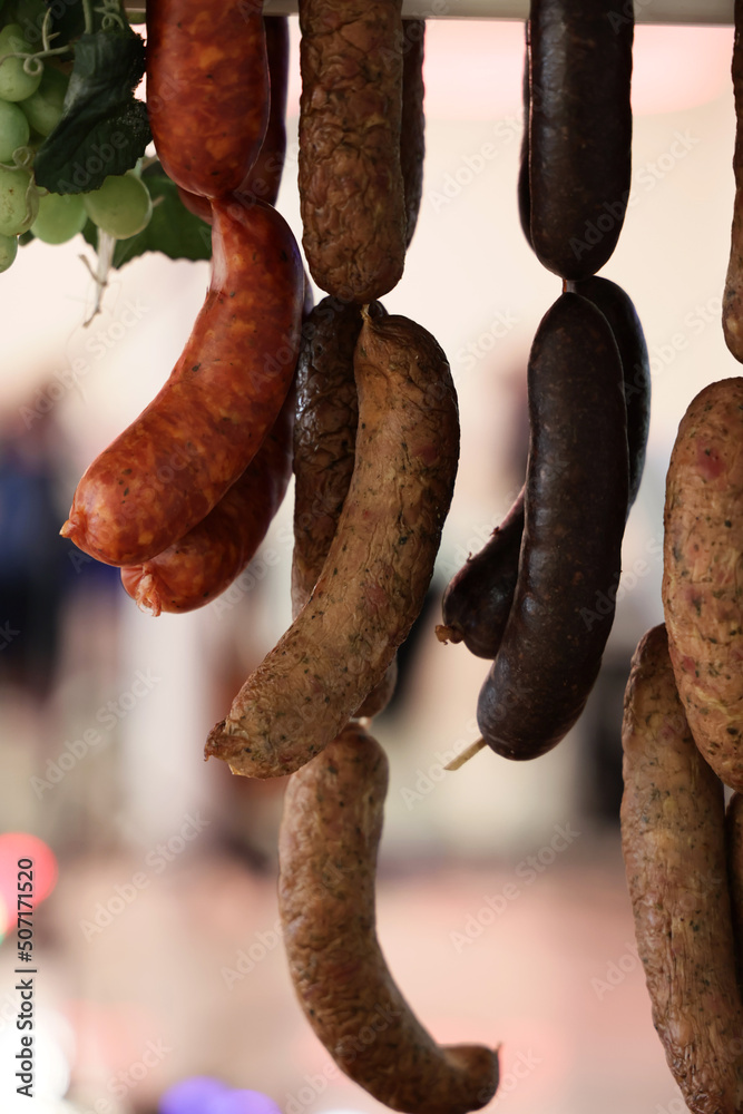 Fototapeta premium Swojska tradycyjna kiełbasa wieprzowa wisi na haku. 