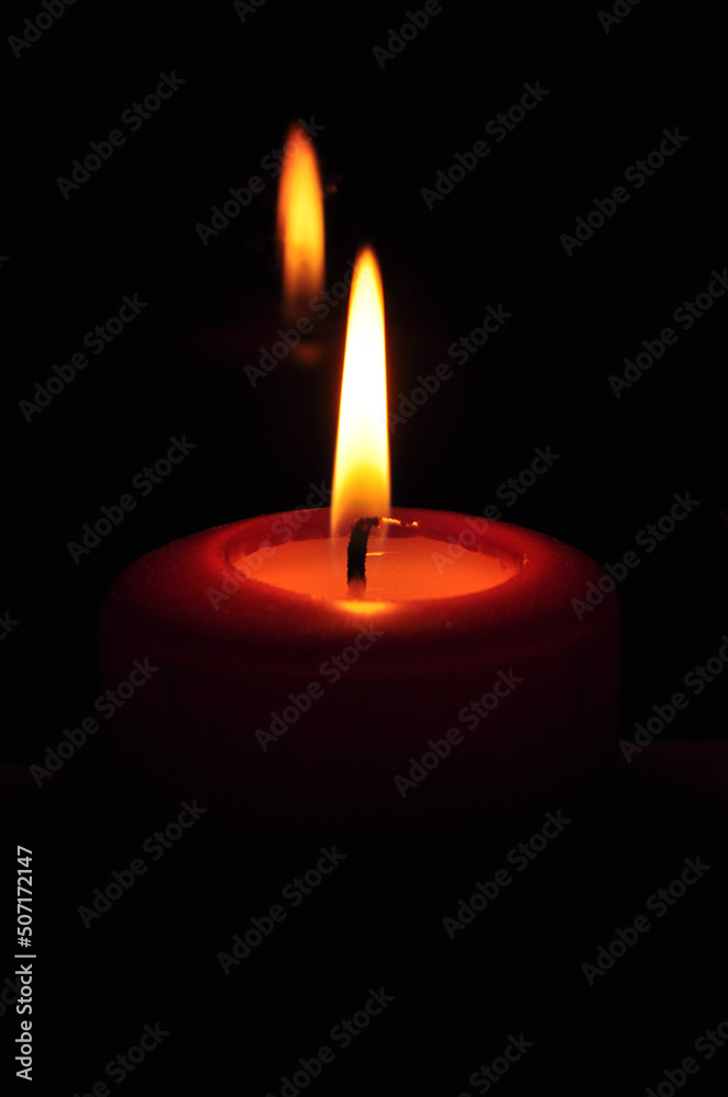 Photo of large burning candles standing on a chest of drawers. Romantic evening for two. Home decor. Comfort and warmth. Photo of large burning candles standing on a chest of drawers. Romantic evening for two. Home decor. Comfort and warmth.