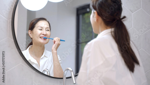 洗面台で歯を磨くミドル女性 photo