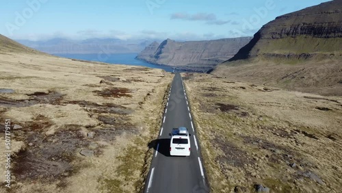 White campervan driving at an scenic road at Feroe Islands photo