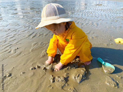 little child playing on the mudflat