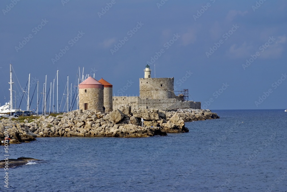 Towers along the edge of Mandraki harbour on the island of Rhodes, Greece