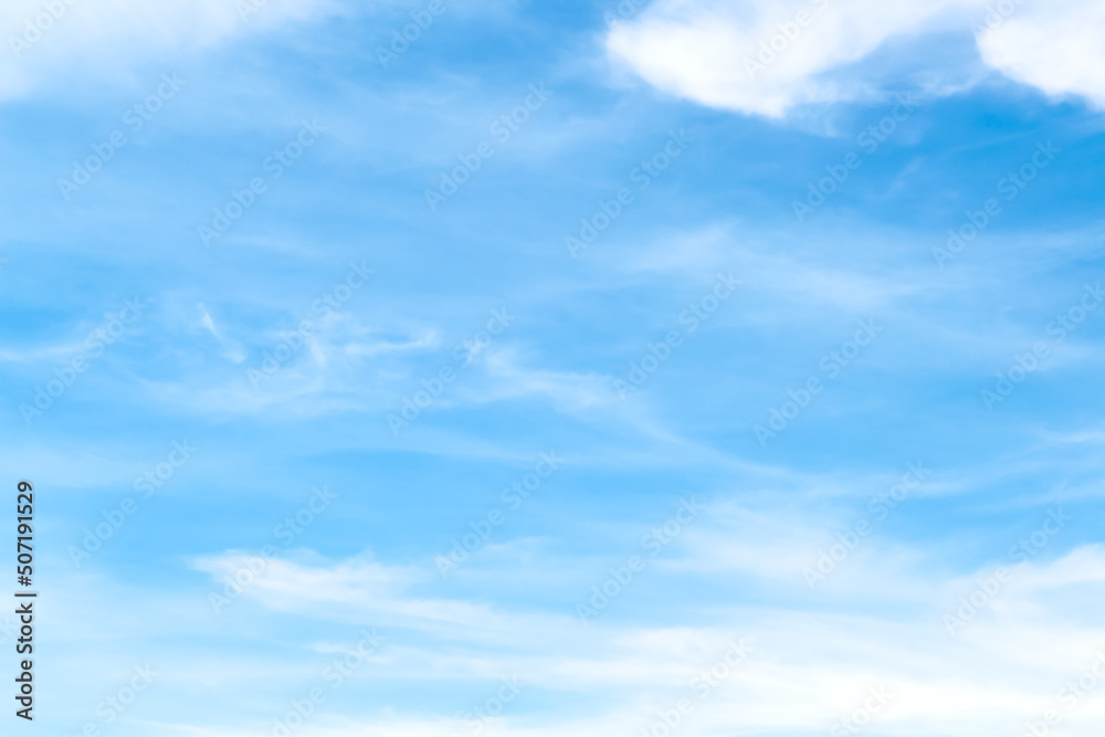 Bright blue sky with soft white clouds patterns on vast scenic summer background and light breeze