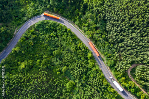 Transporting wind turbine propeller through curvy jungle road. Clean alternative energy to reduce global warming and climate change for sustainable growth.