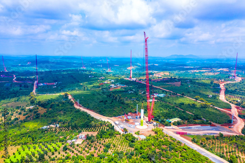 Installing of wind turbine tower with construction crane  Power plant in nature. Aerial view to wind farm. Green energy concept to reduce global warming and climate change for sustainable growth.