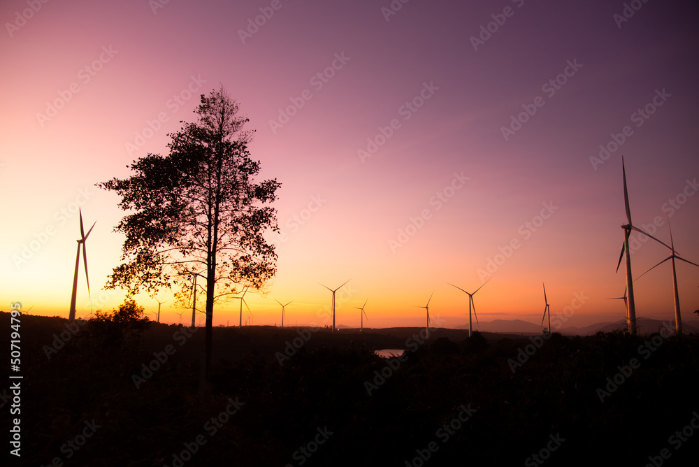Wind turbines power plant at sunset are alternative electricity, the concept of sustainable resources. Green energy concept to reduce global warming and climate change and pollution