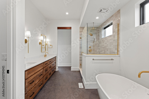 white bathroom with hardwood flooring  white soaker tub and dual sinks