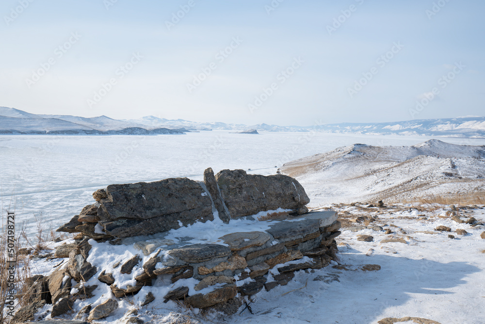 Baikal lake in winter with transparent cracked blue ice. Beautiful winter landscape. Baikal, Siberia, Russia. Baikal lake in winter with transparent cracked blue ice. Beautiful winter landscape. Baikal, Siberia, Russia.
