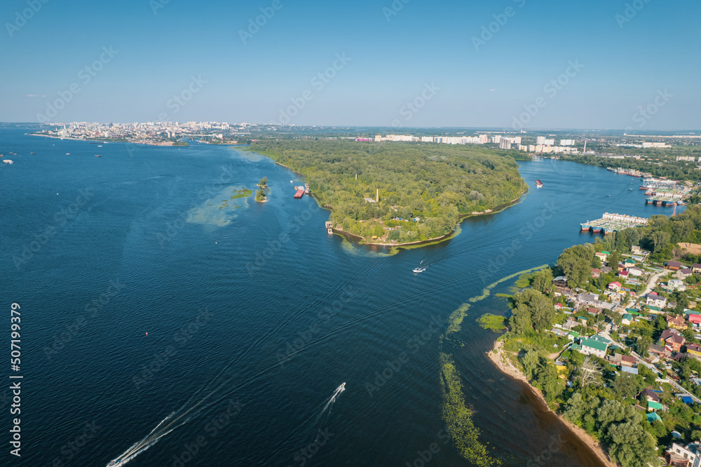 Aerial landscape view on Volga river with islands and green forest. Picturesque panoramic view from the height on the touristic part of the Volga river near Samara city at summer sunny day. Aerial landscape view on Volga river with islands and green forest. Picturesque panoramic view from the height on the touristic part of the Volga river near Samara city at summer sunny day.