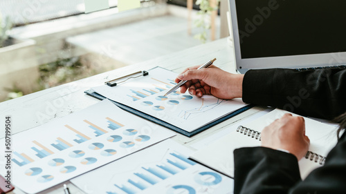 Business analyst working - hand with pen at desk.