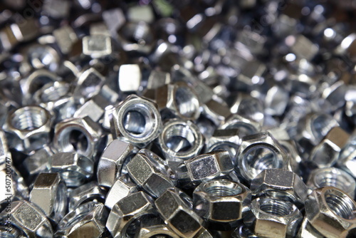 Obraz na płótnie A lot of new shiny grey nuts in perspective. Galvanized construction fasteners. Technical texture for the background. w salonie