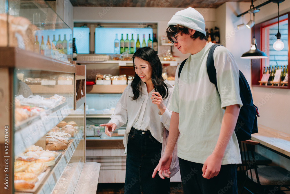 Obraz premium パンを選ぶ母親と10代の息子