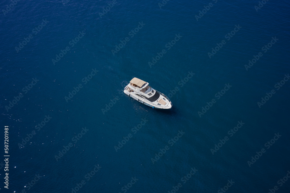 Yacht on blue water. Aerial view luxury motor boat. Top view of the boat.